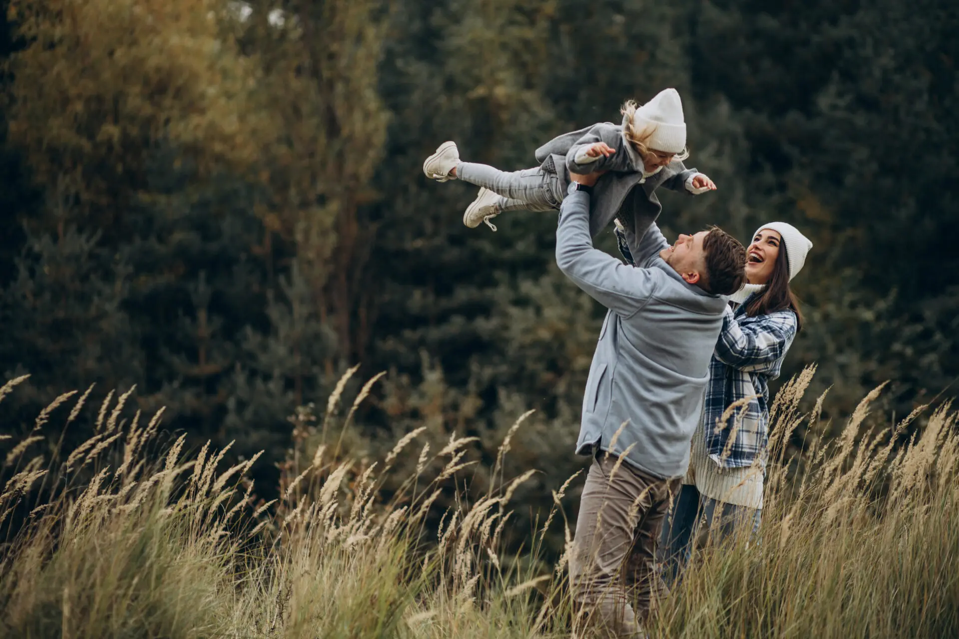 Family With Little Daughter Together In Autumnal Weather Having Fun